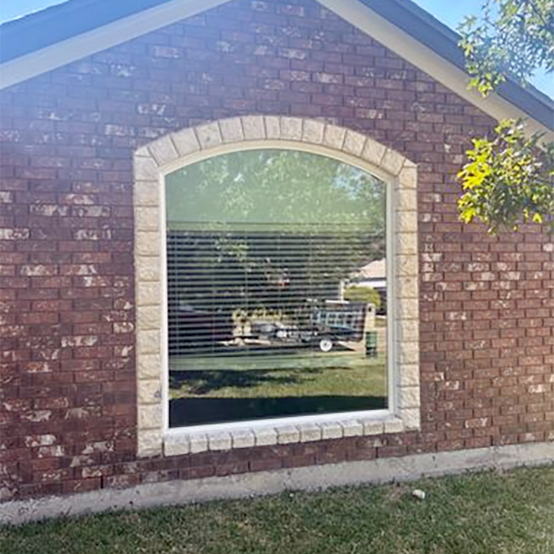 arched picture window installed in a brick exterior providing natural light, clean design, and durable performance for a Wilmington North Carolina home