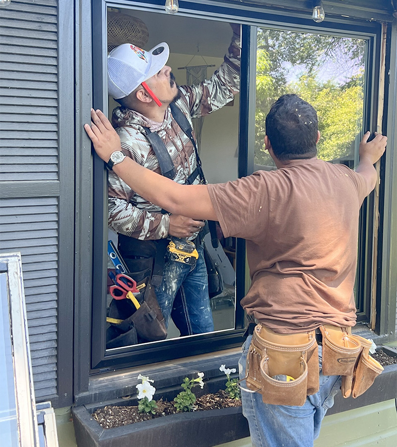 window installation crew securing and sealing replacement window with precision to prevent moisture intrusion and ensure long term performance in coastal Carolina home