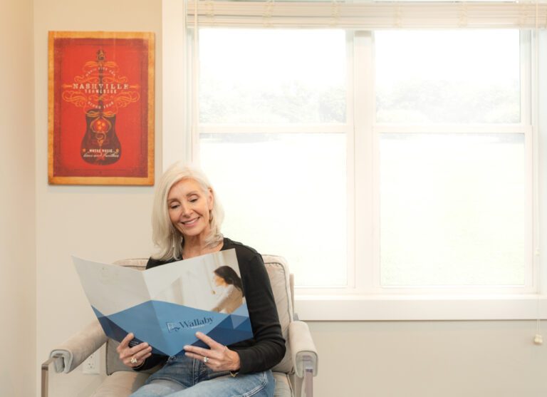 Woman reading a Wallaby Windows brochure about financing and payment promotions in her Cary NC home