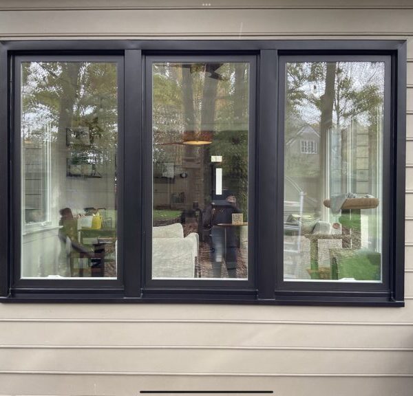 Sleek black-frame fixed windows installed on gray home exterior