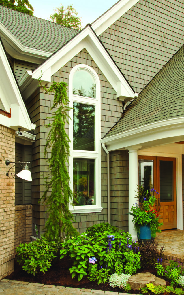 Exterior view of home with tall arched custom window