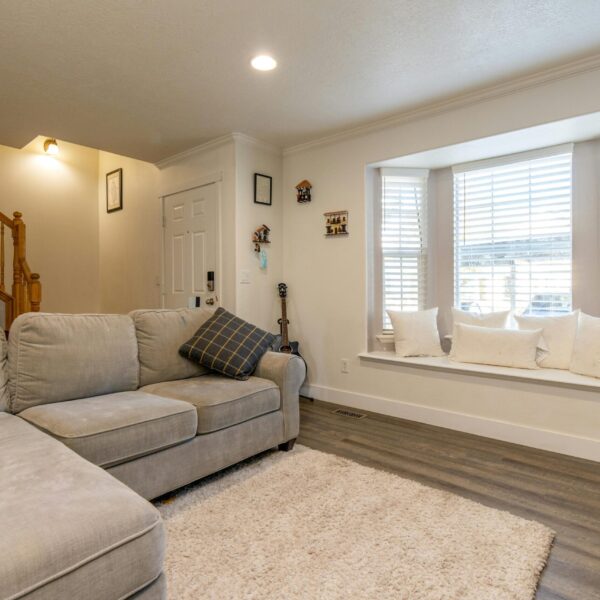 Cozy living room with bay window seat and white blinds