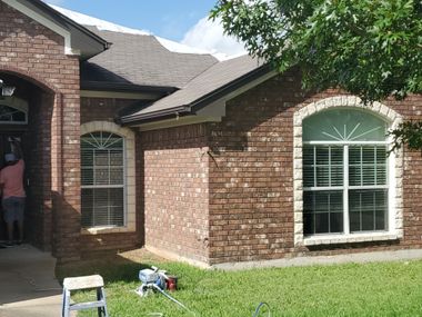 Brick home with outdated geometric windows before replacement